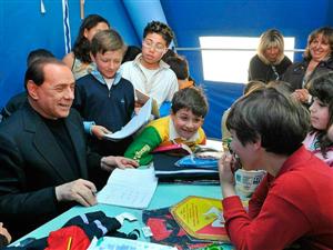 O primeiro-ministro Silvio Berlusconi (esq.) visita sala de aula improvisada em acampamento para desabrigados em L'Aquila